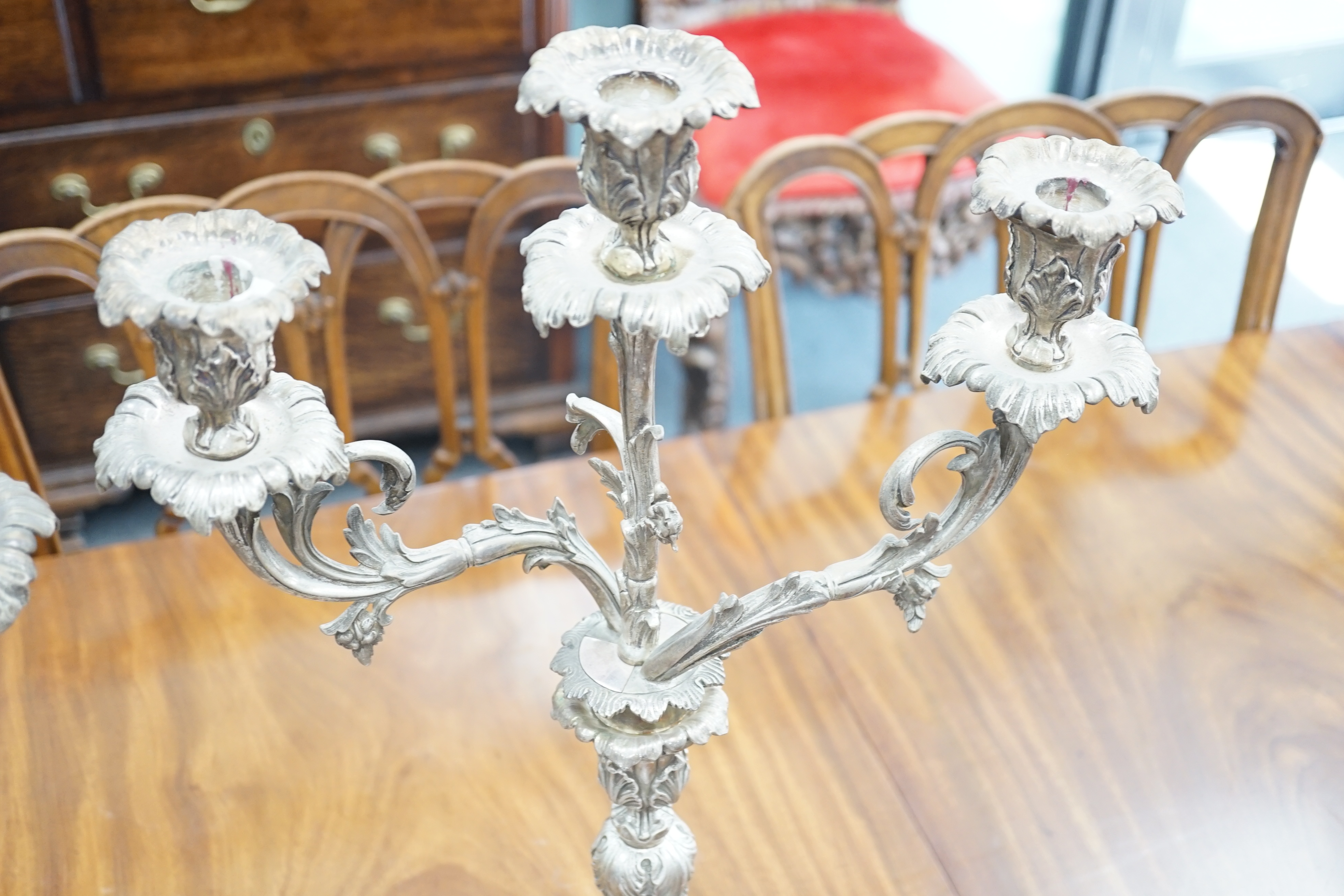 A large pair of plated two branch, three light candelabra, 58cm high, 37cm wide